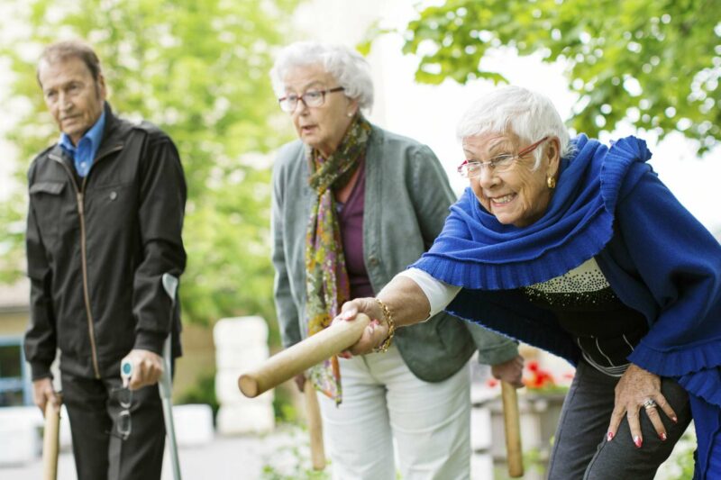 äldre kvinnor och man spelar kubb