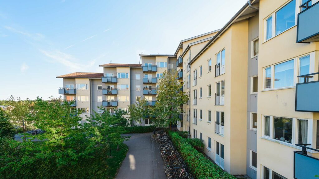 fasadbild mot innergård med gröna träd och buskar