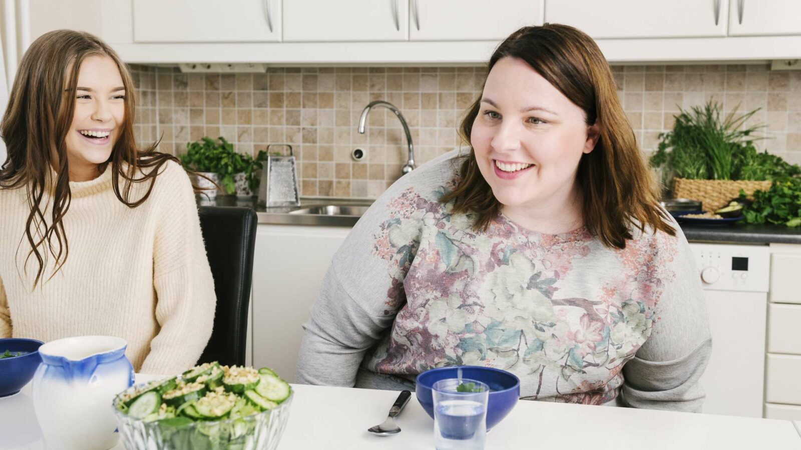 två tjejer skrattar i ett kök