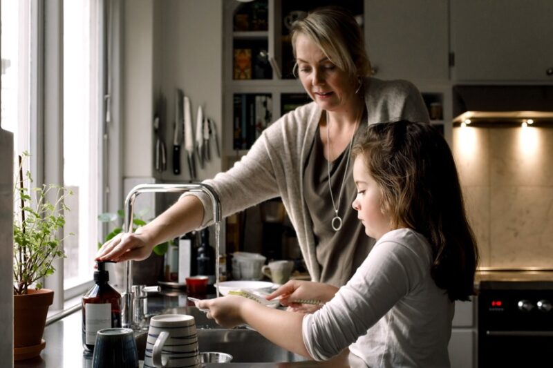 mamma och barn diskar i ett kök