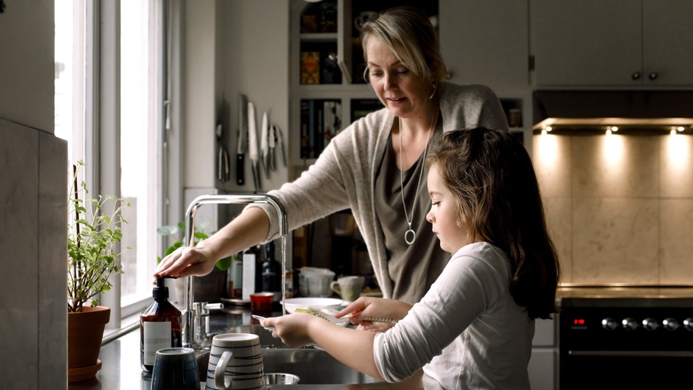 mamma och barn diskar i ett kök